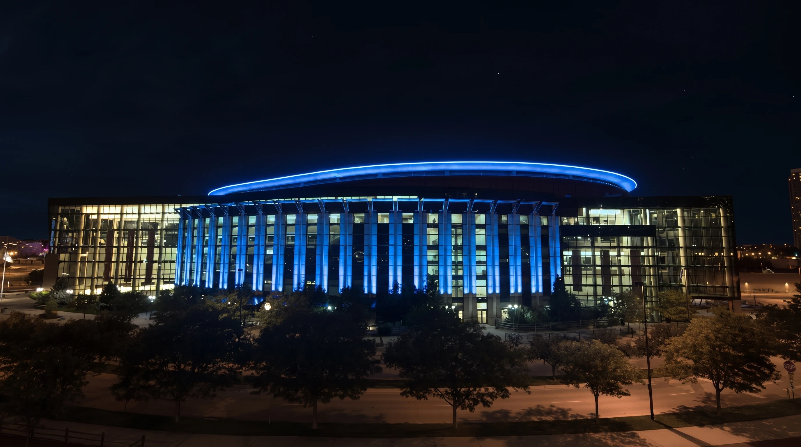 Ball Arena exterior at night with a restrained electric-blue roofline signal